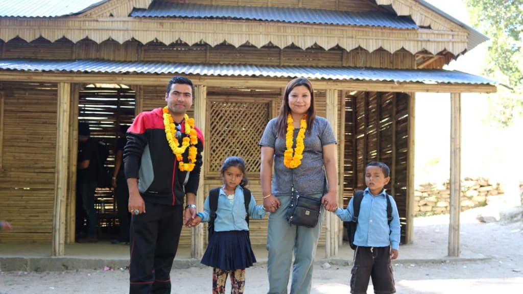 The rebuilt bamboo schoolhouse at Lagarche with families gathered at its handover.