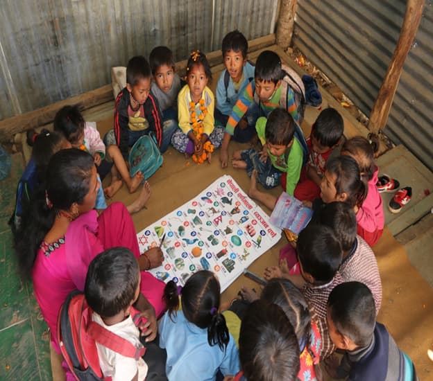 Children learning together inside a temporary learning centre.
