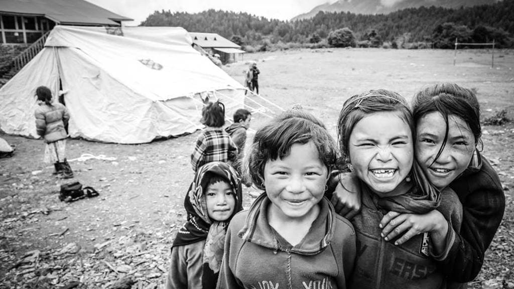 Children smiling together at a settlement in the hills after the earthquake.